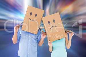 Composite image of couple wearing sad face boxes on their heads