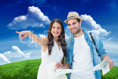 Composite image of happy hipster couple looking at map