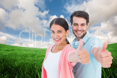 Composite image of happy couple showing thumbs up