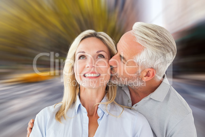 Composite image of affectionate man kissing his wife on the chee