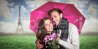 Composite image of cheerful young couple with flowers and umbrel