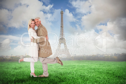 Composite image of happy couple posing in trench coats