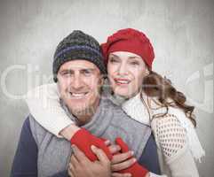 Composite image of happy couple in warm clothing