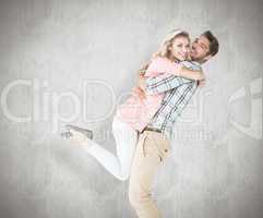 Composite image of handsome man picking up and hugging his girlf