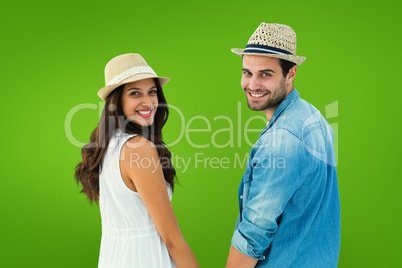 Composite image of happy hipster couple holding hands and smilin