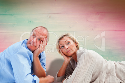 Composite image of mature couple lying and thinking