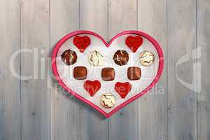 Composite image of heart shaped box of candy
