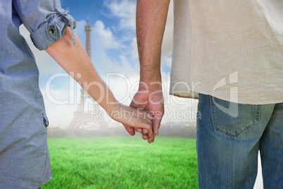 Composite image of couple holding hands in park