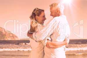 Happy couple on the beach smiling at each other