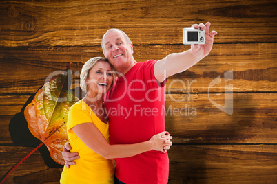 Composite image of happy mature couple taking a selfie together