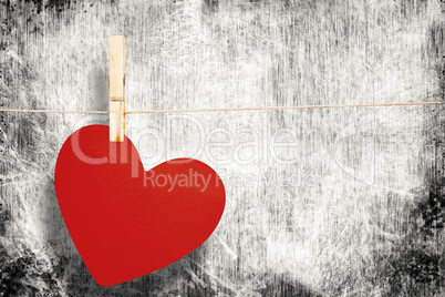 Composite image of heart hanging on line