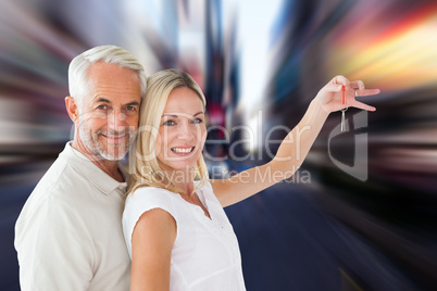 Composite image of happy couple showing their new house key