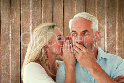 Composite image of woman whispering a secret to husband