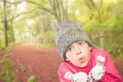 Composite image of wrapped up little girl blowing over hands