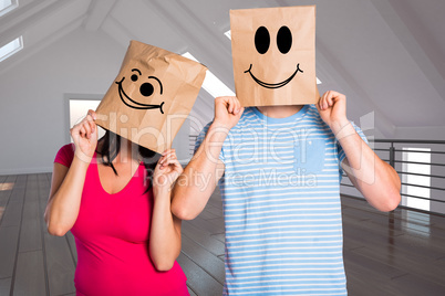 Composite image of young couple with bags over heads