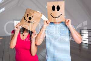 Composite image of young couple with bags over heads