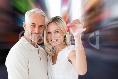 Composite image of happy couple showing their new house key