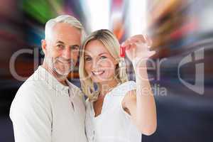 Composite image of happy couple showing their new house key