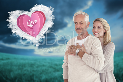 Composite image of happy couple standing and hugging