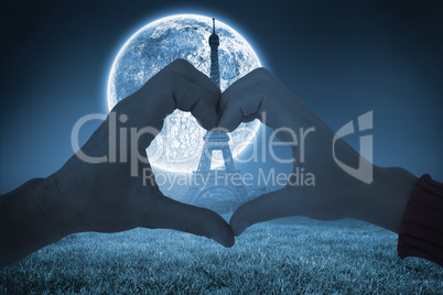 Composite image of couple making heart shape with hands