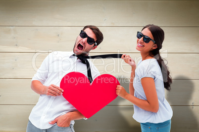 Composite image of brunette pulling her boyfriend by the tie hol