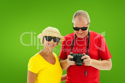 Composite image of happy mature couple wearing sunglasses