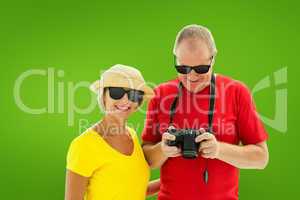 Composite image of happy mature couple wearing sunglasses