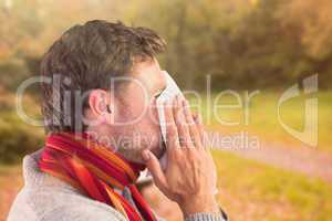 Composite image of man blowing nose on tissue