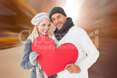 Composite image of smiling couple in winter fashion posing with