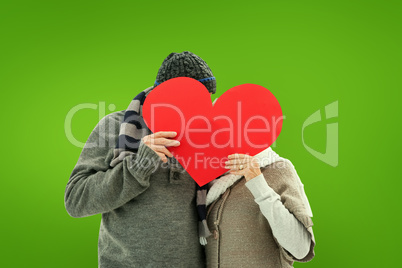 Composite image of happy mature couple in winter clothes holding