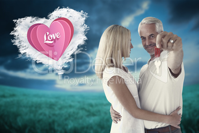 Composite image of happy couple showing their new house key