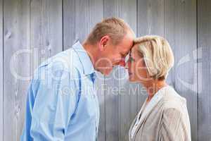 Composite image of happy mature couple facing each other