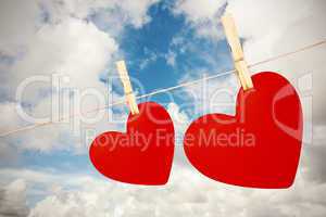 Composite image of hearts hanging on a line