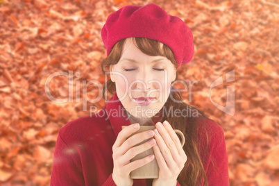 Composite image of woman holding a warm cup