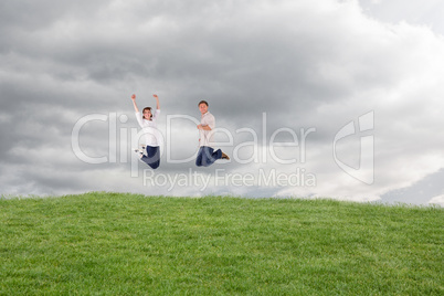 Composite image of couple jumping in the air