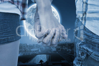 Composite image of couple in check shirts and denim holding hand