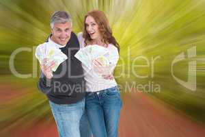 Composite image of casual couple showing their cash