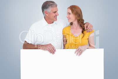 Composite image of casual couple showing a poster