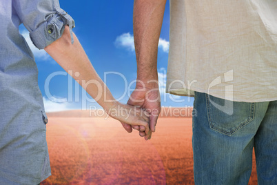 Composite image of couple holding hands in park