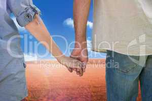 Composite image of couple holding hands in park