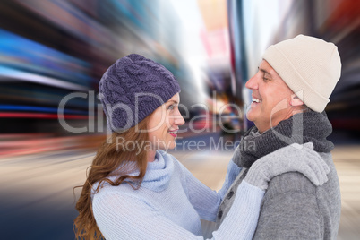 Composite image of happy couple in warm clothing