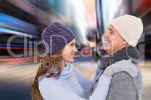 Composite image of happy couple in warm clothing