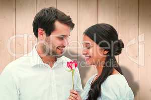 Composite image of handsome man offering his girlfriend a rose