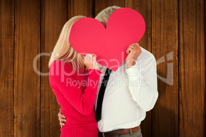 Composite image of handsome man getting a heart card form wife