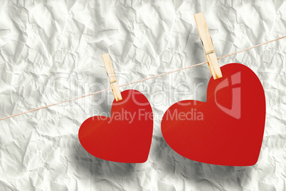 Composite image of hearts hanging on a line