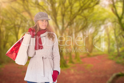 Composite image of happy blonde in winter clothes with bags