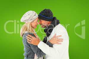 Composite image of happy couple in winter fashion embracing