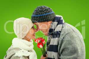 Composite image of happy mature couple in winter clothes with ro