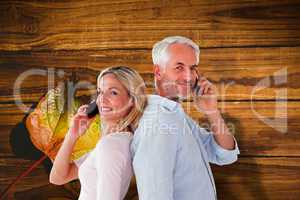 Composite image of happy couple talking on their smartphones