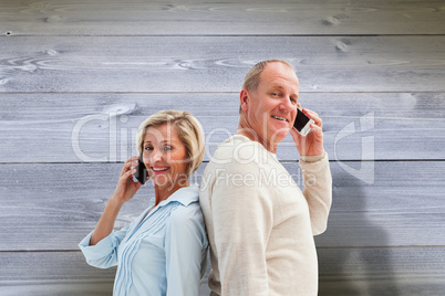 Composite image of happy mature couple talking on their phones